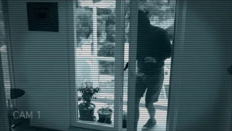 a photo from a security camera feed of a man entering a house
