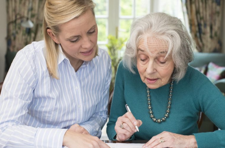 two women leaning over a paper