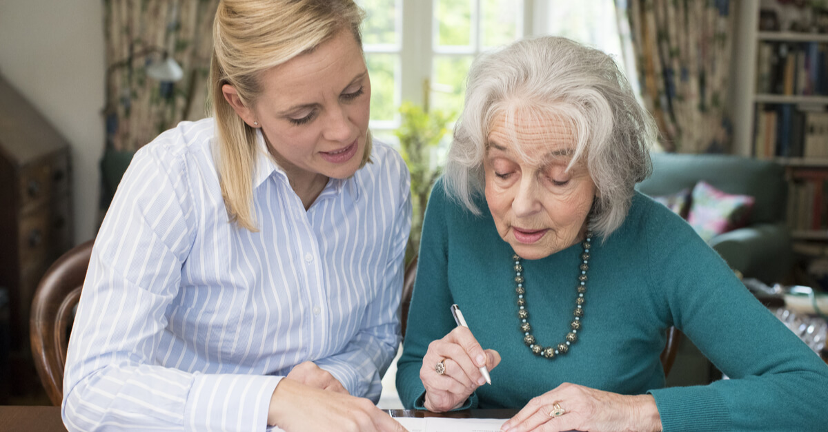 two women leaning over a paper