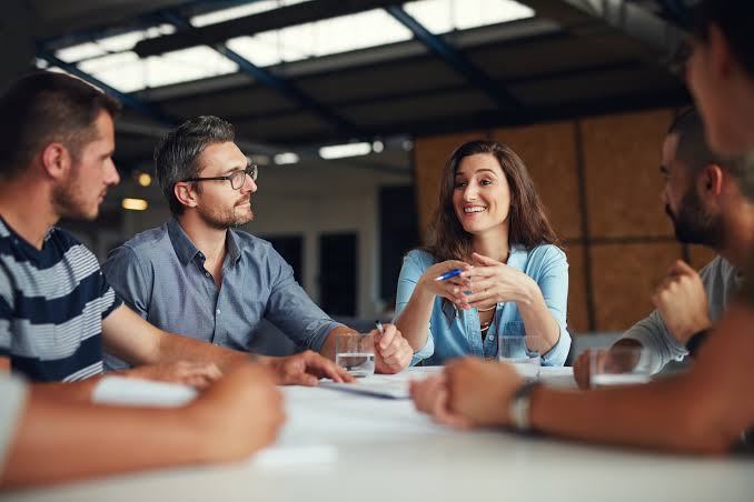 poeple talking at an office meeting