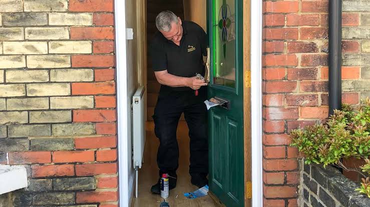 a man inside a house staying in fron of the open door 