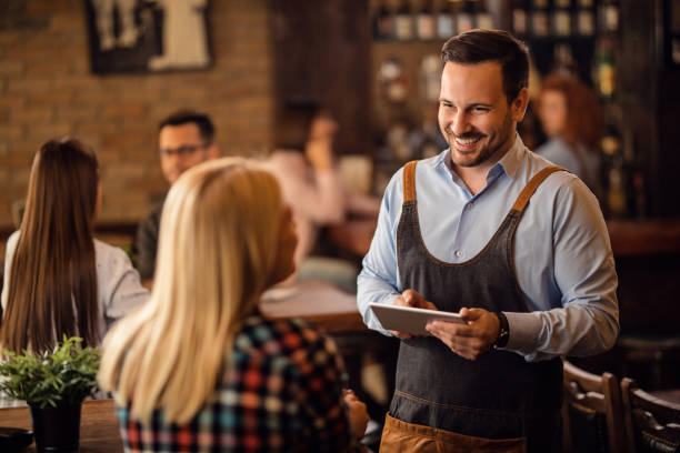 a waiter talking with a woman at a restaurant
