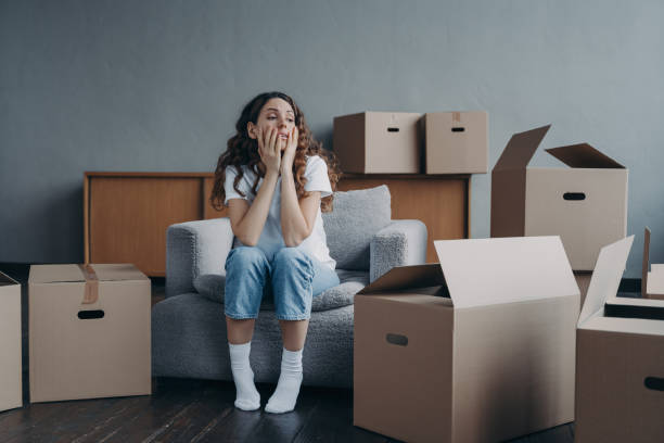 worried womann sitting amoung moving boxes
