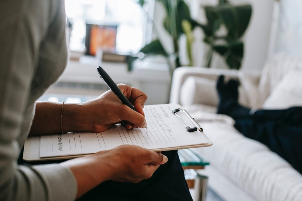 a woman writing on a paper pad