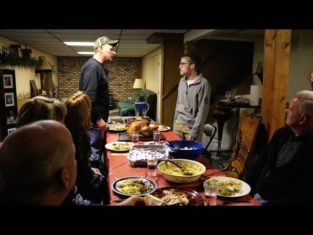 two men arguing at a family dinner table