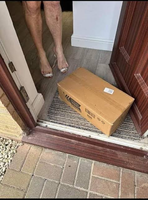 woman standing in front a a open door with a delivery package on the floor