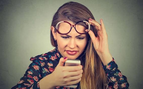 confused woman looking at her phone