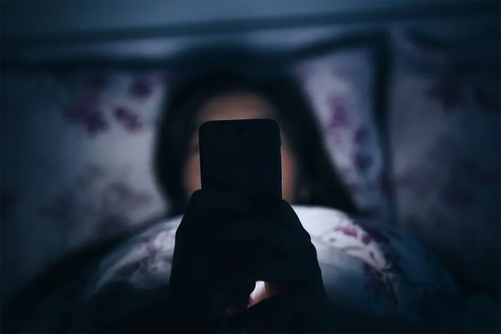 woman in the dark checking her phone